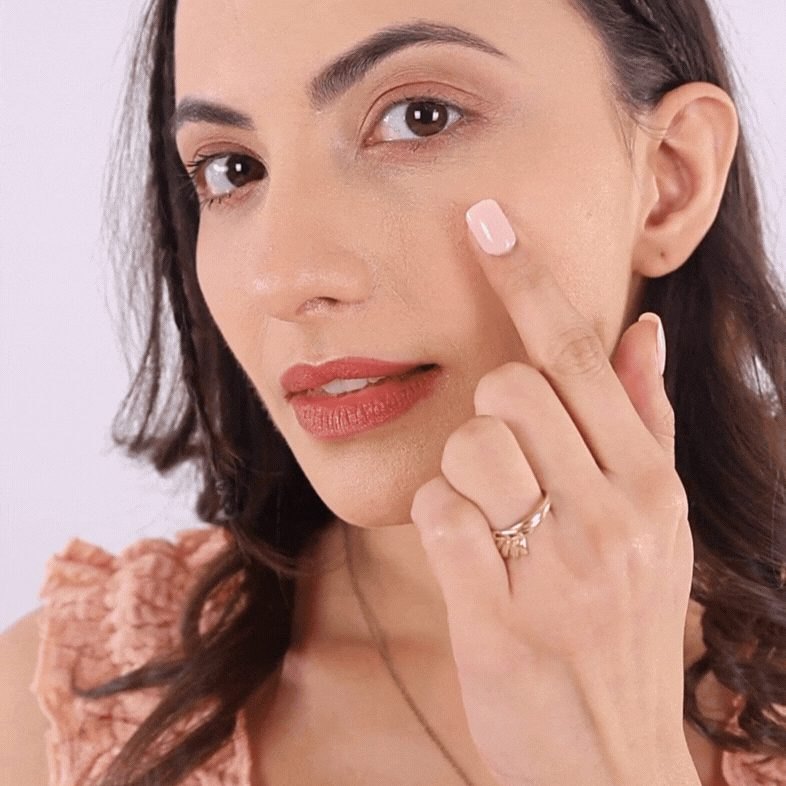 Woman touching smooth, even skin on her cheek