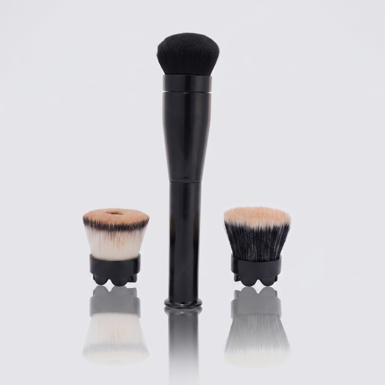 Flaminglo rotating makeup brush handle standing next to two brush heads