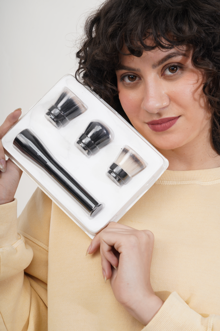 Woman holding the Flaminglo brush kit, showing the handle and swappable heads